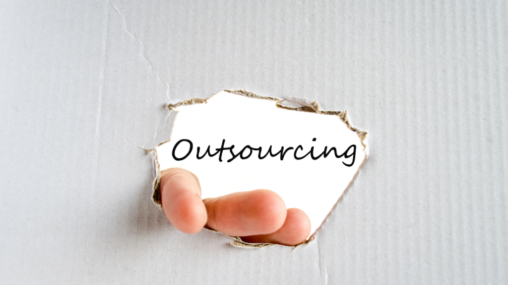 破った段ボールの先に「Outsourcing」の文字