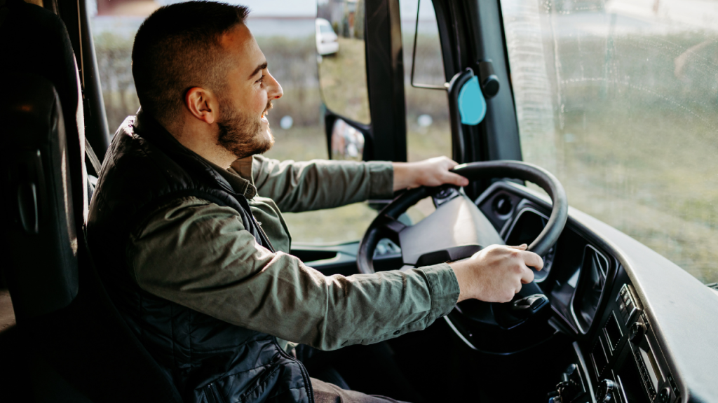 トラックを笑顔で運転してる男性の横向き画像